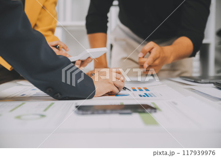 Financial analysts analyze business financial reports on a digital tablet planning investment project during a discussion at a meeting of corporate showing the results of their successful teamwork. Financial analysts analyze business financial reports on a digital tablet planning investment project during a discussion at a meeting of corporate showing the results of their successful teamwork. 117939976