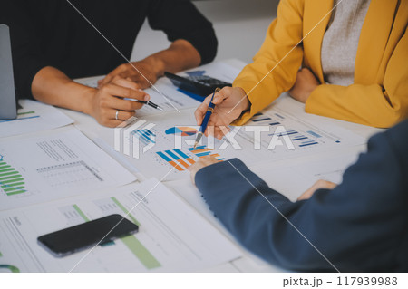 Financial analysts analyze business financial reports on a digital tablet planning investment project during a discussion at a meeting of corporate showing the results of their successful teamwork. 117939988