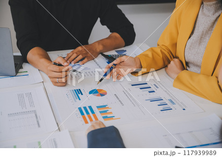 Financial analysts analyze business financial reports on a digital tablet planning investment project during a discussion at a meeting of corporate showing the results of their successful teamwork. 117939989