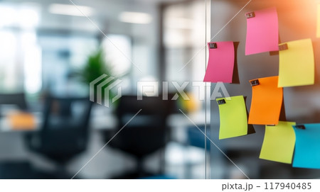 Colorful sticky notes on a glass surface in a well-lit office. Represents business planning, creative brainstorming, and task management. 117940485