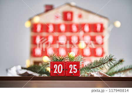 Christmas Advent calendar in the shape of a house with boxes making up the number 2025. 117940814