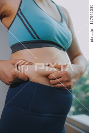 fat woman, fat belly, chubby, obese woman hand holding excessive belly fat with measure tape, woman diet lifestyle concept fat woman, fat belly, chubby, obese woman hand holding excessive belly fat with measure tape, woman diet lifestyle concept 117941039