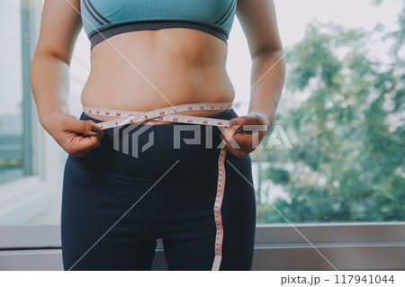fat woman, fat belly, chubby, obese woman hand holding excessive belly fat with measure tape, woman diet lifestyle concept fat woman, fat belly, chubby, obese woman hand holding excessive belly fat with measure tape, woman diet lifestyle concept 117941044