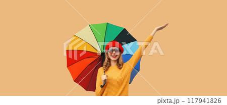 Autumn color, beautiful happy cheerful young woman holding colorful umbrella, stylish joyful girl Autumn color, beautiful happy cheerful young woman holding colorful umbrella, stylish joyful girl 117941826