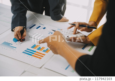 Financial analysts analyze business financial reports on a digital tablet planning investment project during a discussion at a meeting of corporate showing the results of their successful teamwork. 117942103