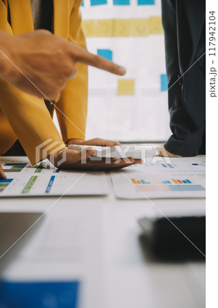 Financial analysts analyze business financial reports on a digital tablet planning investment project during a discussion at a meeting of corporate showing the results of their successful teamwork. 117942104