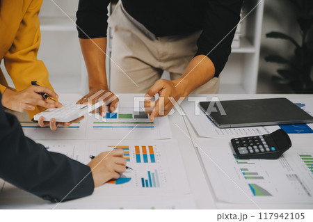 Financial analysts analyze business financial reports on a digital tablet planning investment project during a discussion at a meeting of corporate showing the results of their successful teamwork. 117942105