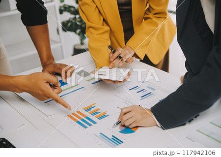 Financial analysts analyze business financial reports on a digital tablet planning investment project during a discussion at a meeting of corporate showing the results of their successful teamwork. 117942106