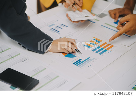Financial analysts analyze business financial reports on a digital tablet planning investment project during a discussion at a meeting of corporate showing the results of their successful teamwork. 117942107