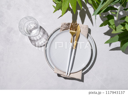 Festive table setting with blue plates and glass for a celebration with eucalyptus branches 117943137