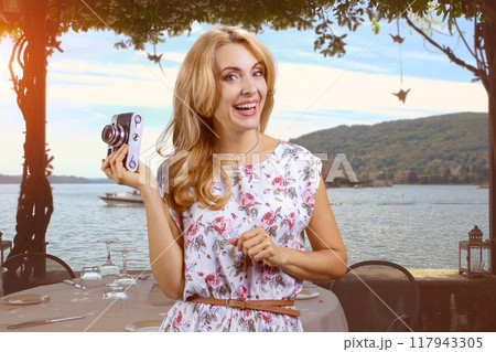 Woman on the beach with vintage photo camera. Sea landscape in the background. Woman on the beach with vintage photo camera. Sea landscape in the background. 117943305