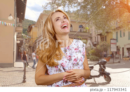 Cheerful happy caucasian mature woman laughing outdoors. City street in the background. Cheerful happy caucasian mature woman laughing outdoors. City street in the background. 117943341