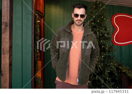 Handsome man in trendy clothes standing near 117945331