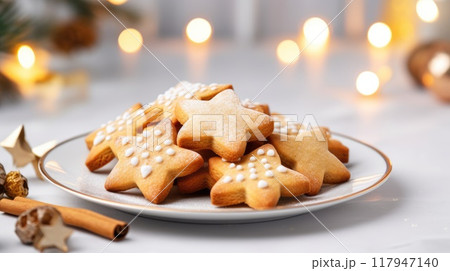 Homemade Christmas gingerbread cookies decorated with sweet sugar icing served on plate on white wooden background 117947140