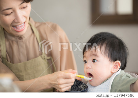 離乳食を食べる赤ちゃんとお母さん 家族の食卓 離乳食を食べる赤ちゃんとお母さん 家族の食卓 117947586