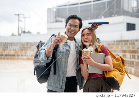 A lovely young Asian college student couple is walking together outdoors on a sunny day on campus. 117948827