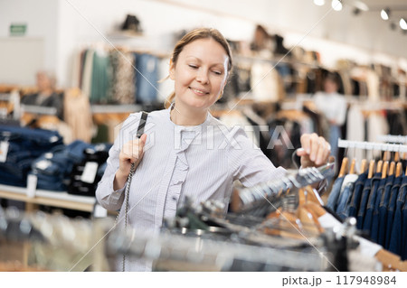 Adult woman walks through clothing store Adult woman walks through clothing store 117948984