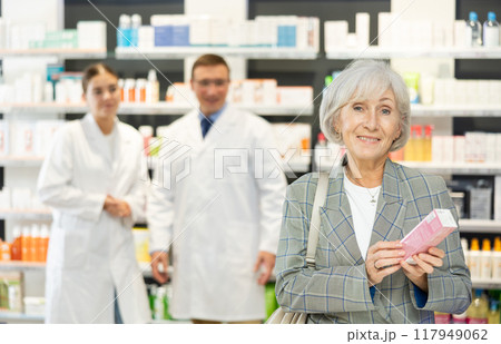 In pharmacy, senior female customer chooses cream for aging skin 117949062