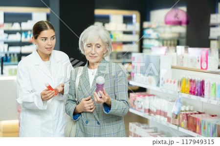Mature lady choosing lubricant with help of young female pharmacist 117949315