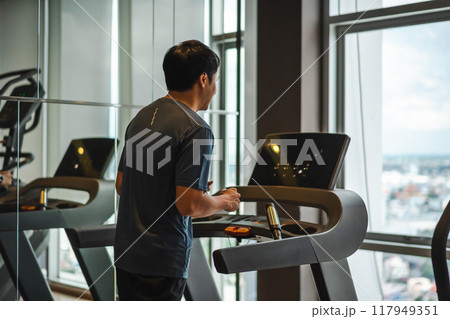man running on treadmill at fitness gym exercise man running on treadmill at fitness gym exercise 117949351