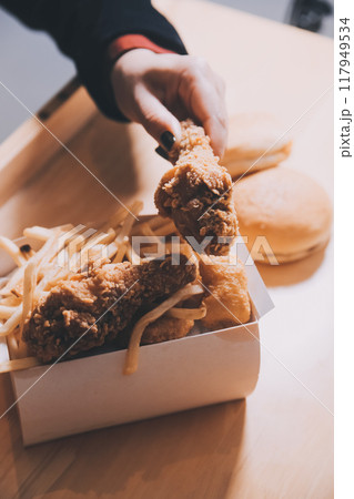 close up focus woman hand hold fried chicken for eat,girl with fast food concept close up focus woman hand hold fried chicken for eat,girl with fast food concept 117949534