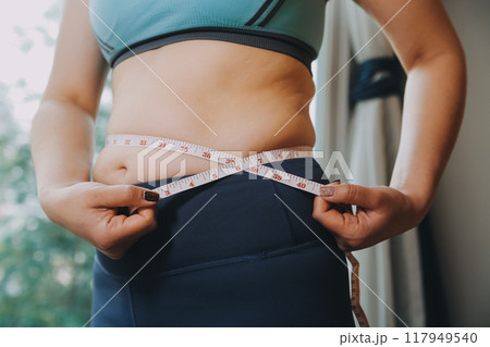 fat woman, fat belly, chubby, obese woman hand holding excessive belly fat with measure tape, woman diet lifestyle concept fat woman, fat belly, chubby, obese woman hand holding excessive belly fat with measure tape, woman diet lifestyle concept 117949540