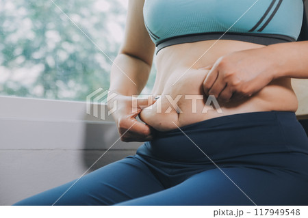 fat woman, fat belly, chubby, obese woman hand holding excessive belly fat with measure tape, woman diet lifestyle concept fat woman, fat belly, chubby, obese woman hand holding excessive belly fat with measure tape, woman diet lifestyle concept 117949548