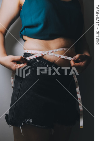 fat woman, fat belly, chubby, obese woman hand holding excessive belly fat with measure tape, woman diet lifestyle concept fat woman, fat belly, chubby, obese woman hand holding excessive belly fat with measure tape, woman diet lifestyle concept 117949591
