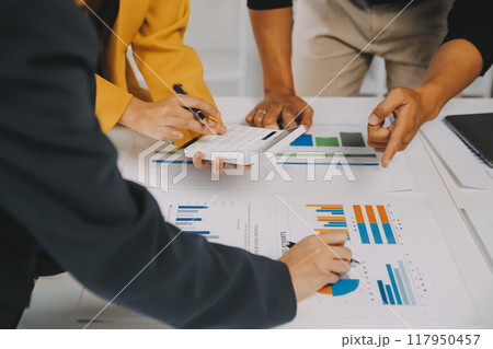 Financial analysts analyze business financial reports on a digital tablet planning investment project during a discussion at a meeting of corporate showing the results of their successful teamwork. 117950457