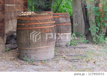 Wooden barrels with metal hoops. Countryside. 117950553