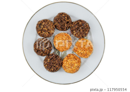 Variety of cakes in ceramic plate isolated on a white background. Yellow and brown romantic biscuit. Top view. 117950554
