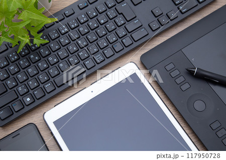 デスクの上に置かれたペンタブレット　キーボード　iPad　スマホ 117950728