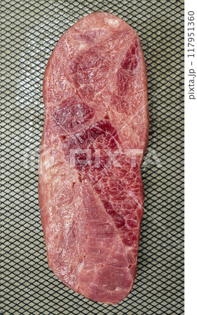 A piece of sirloin meat is sliced and placed on a baking sheet 117951360