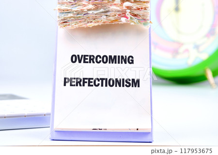 Business Overcoming perfectionism concept. Copy space. Concept words Overcoming perfectionism in a desktop calendar on a light background 117953675