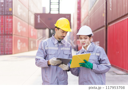 Smart and good looking Asian male and female container yard officers making a handshake together. Team of logistic engineer is working at the container yard. Smart and good looking Asian male and female container yard officers making a handshake together. Team of logistic engineer is working at the container yard. 117953708