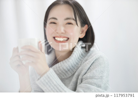 マグカップを持つセーターを着た若い女性 マグカップを持つセーターを着た若い女性 117953791