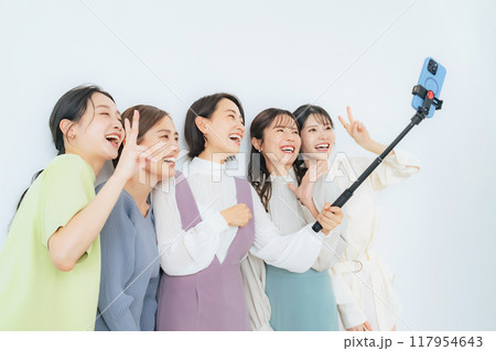 自撮り棒で自撮りするカジュアルな女性グループ 117954643