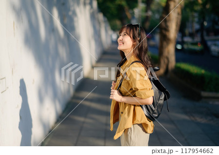 Traveler young asian woman in her 30s embarks on a solo trip to Bangkok. This photo captures the essence of finding balance and exploring new destinations. 117954662