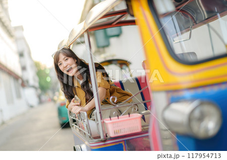Attractive beautiful tourist woman or traveler woman sitting on tuk tuk taxi exploring the city on summer vacations, Khao San Road walking street at Bangkok, Thailand. Attractive beautiful tourist woman or traveler woman sitting on tuk tuk taxi exploring the city on summer vacations, Khao San Road walking street at Bangkok, Thailand. 117954713