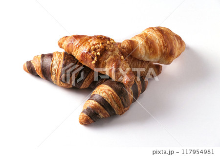 Freshly baked golden croissants in various flavors arranged on a white background. Freshly baked golden croissants in various flavors arranged on a white background. 117954981