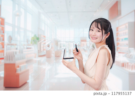 化粧品を購入する若い女性 化粧品を購入する若い女性 117955137