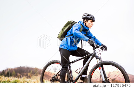 Active man on bike in the middle of beautiful nature, early autumn morning. Concept of healthy lifestyle. Active man on bike in the middle of beautiful nature, early autumn morning. Concept of healthy lifestyle. 117956476