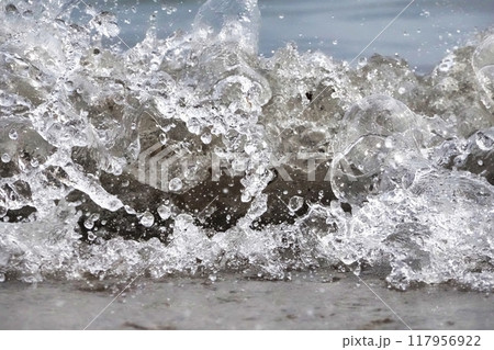 White foam and sea water drop splashes slow motion with sand and blue water White foam and sea water drop splashes slow motion with sand and blue water 117956922
