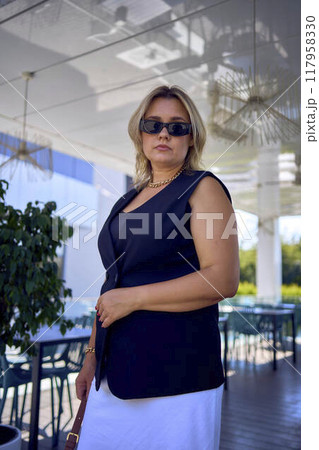 a middle-aged plus size woman in old money style clothes in a fancy restaurant a middle-aged plus size woman in old money style clothes in a fancy restaurant 117958330
