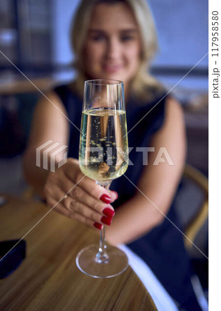 middle-aged plus size woman in old money style clothes drinking sparkling wine in a fancy restaurant middle-aged plus size woman in old money style clothes drinking sparkling wine in a fancy restaurant 117958580