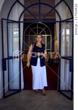 a  middle-aged plus size woman in old money style clothes in a fancy restaurant 117958616