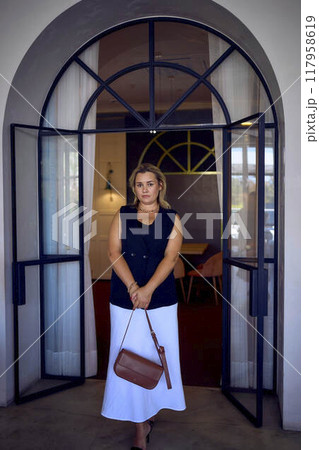 a  middle-aged plus size woman in old money style clothes in a fancy restaurant 117958619