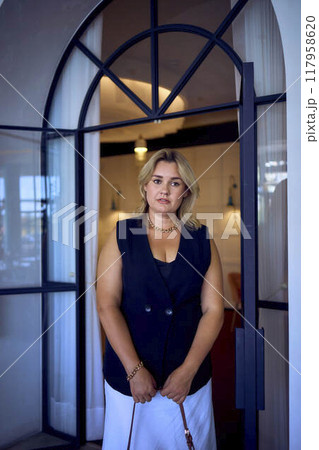 a  middle-aged plus size woman in old money style clothes in a fancy restaurant 117958620