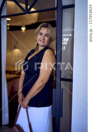 a  middle-aged plus size woman in old money style clothes in a fancy restaurant 117958624
