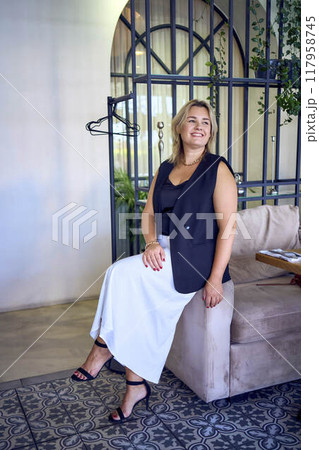 a  middle-aged plus size woman in old money style clothes in a fancy restaurant 117958745
